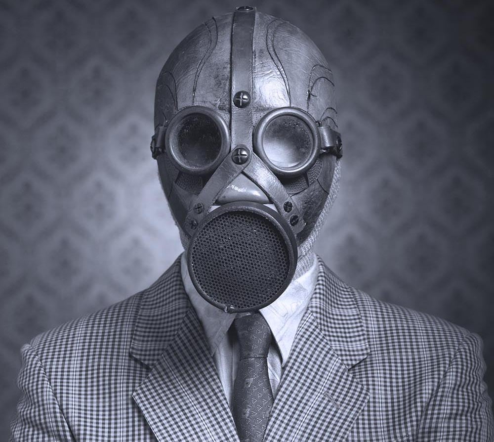 A person in a suit wearing a gas mask